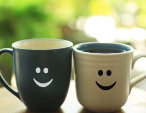 one dark tea cup, one light, both with smiley faces