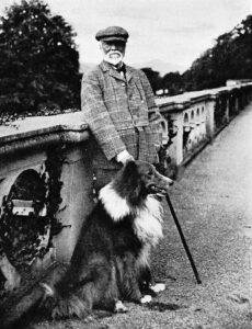 Portrait of andrew Carnegie in tweeds, posed at Skibo Castle with a big collie dog at his side